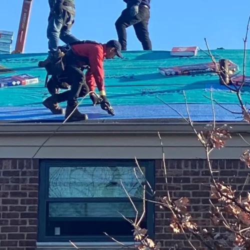 county-roofing-systems-web-worker-on-roof-red-shirt-applying-shingles